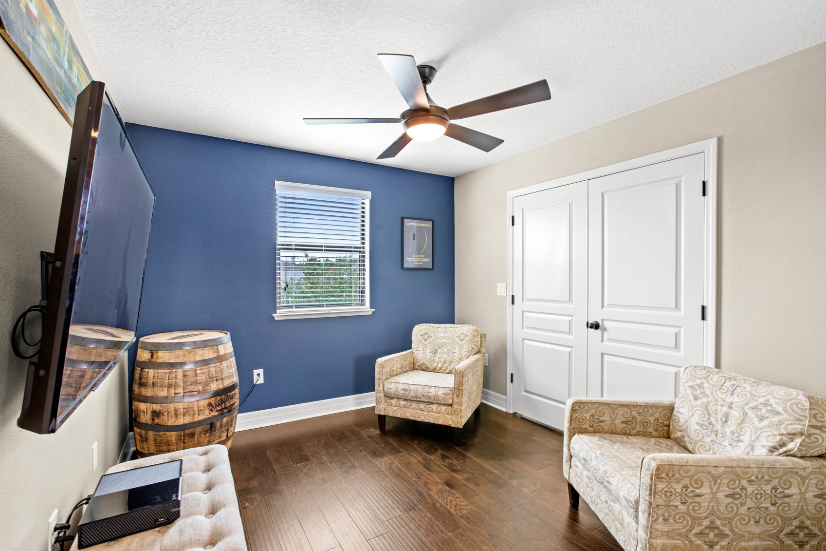 sitting room with chairs and double doors to primary suite